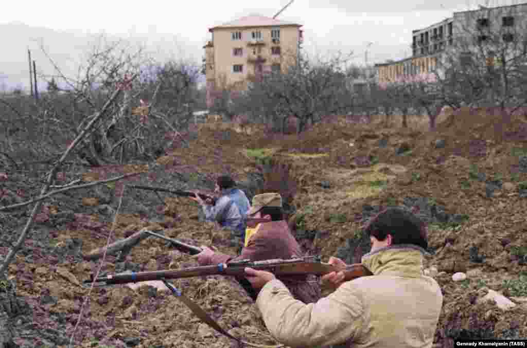 Осетини в окопах на околиці Цхінвалі. Чоловіки використовують застарілі російські гвинтівки Мосіна-Нагана, вперше випущені в 1890-х роках.&nbsp; Протягом 1991 року &laquo;клаптикова ковдра&raquo; грузинських і осетинських селищ, з якої складається Південна Осетія, роздиралася міжетнічними вбивствами і залякуваннями 