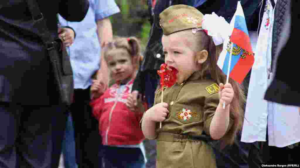 9 травня 2018, Севастополь. Юна кримчанка з бантами і у військовій формі під час святкування російського Дня перемоги