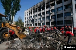 Завалы около сгоревшего здания Горсовета Мариуполя разбирают работники местных предприятий, принадлежащих Ринату Ахметову