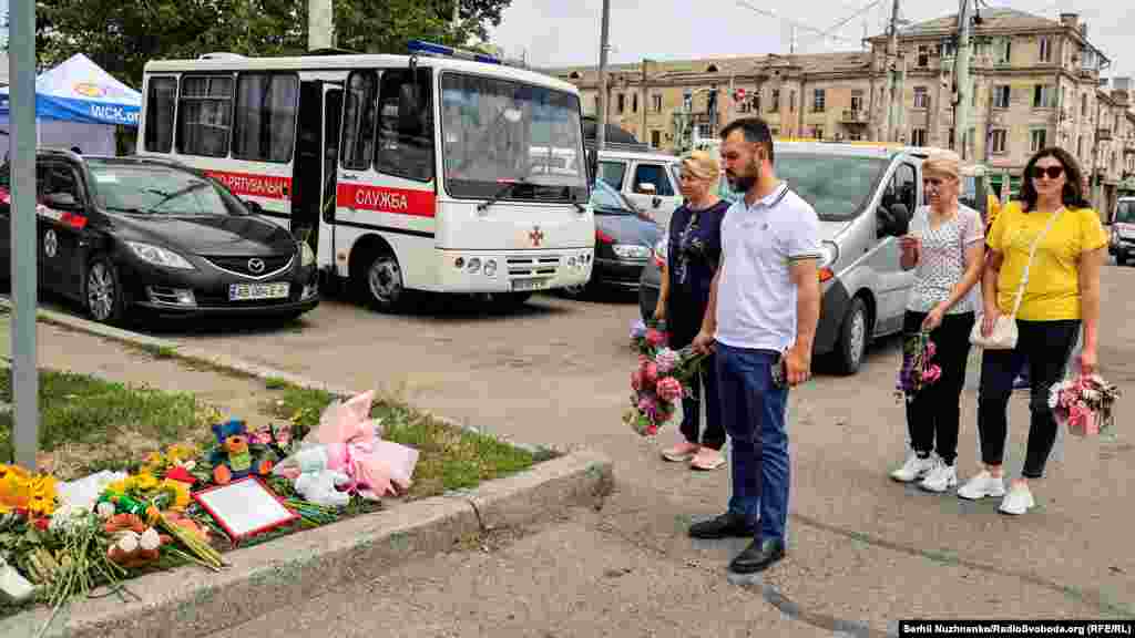 Люди покладають квіти біля імпровізованого меморіалу. На цьому місці загинула чотирирічна Ліза Дмитрієва