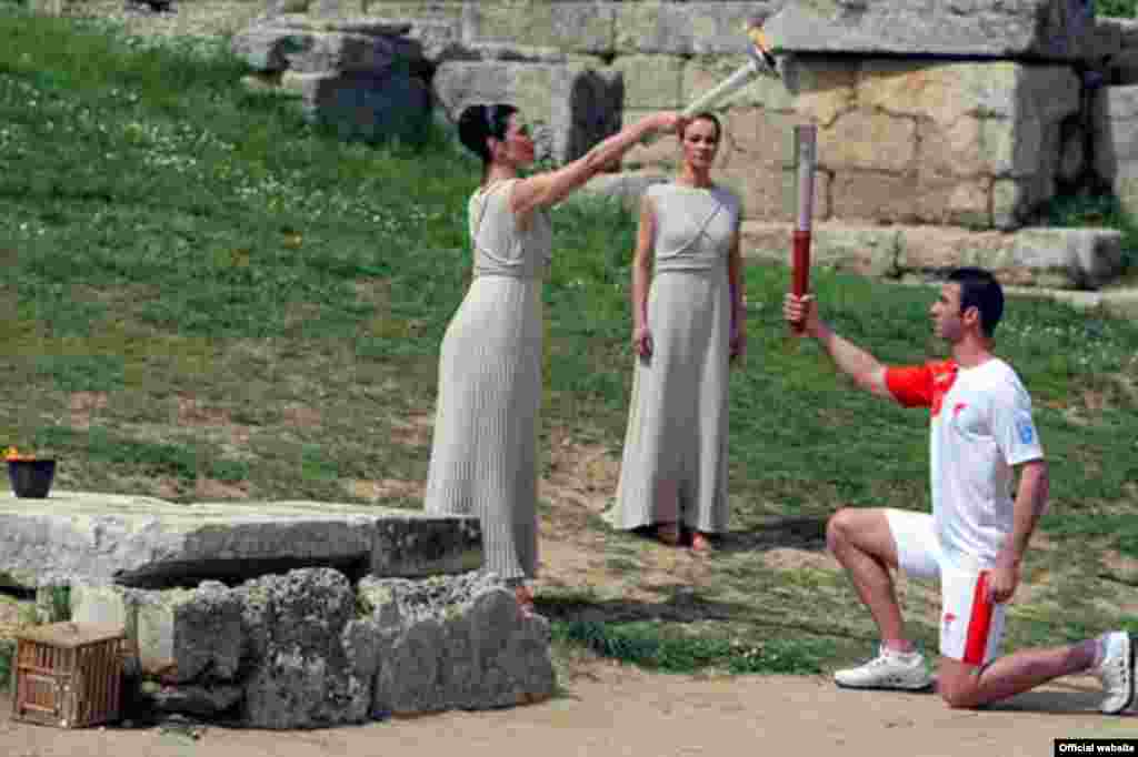 Greece - Actress Maria Nafpliotou, kindles a torch in hand of Greece's Olympic silver medallist for taekwondo Alexandros Nikolaidis during the Olympic flame lighting ceremony for the Beijing 2008 Games in Olympia, 24Mar2008