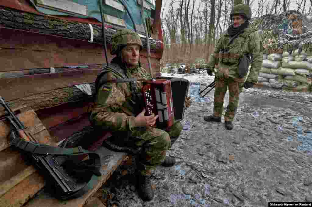 Український військовослужбовець грає музику на лінії зіткнення з підтримуваними Росією бойовиками в Донецькій області на сході України