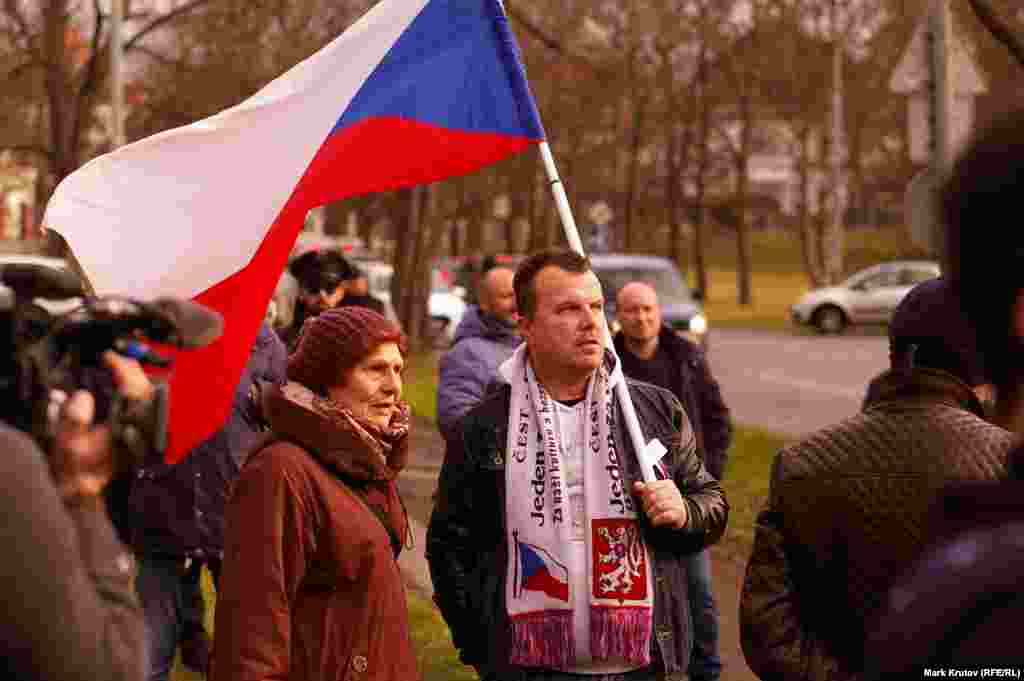 Против переименования выступали и многие жители пражского района Бубенеч, считающие, что площадь можно было бы назвать в честь кого-то из заслуживающих увековечивания чехов. Тем не менее, на торжественное открытие пришло лишь несколько противников переименования. Один из них (на фото он держит флаг Чехии) пытался сорвать церемонию криками и свистом, затеял драку с одним из пришедших сторонников нового названия пощади и почему-то говорил в основном о засилье мигрантов в Чехии и о том, что власти скрывают эту проблему.