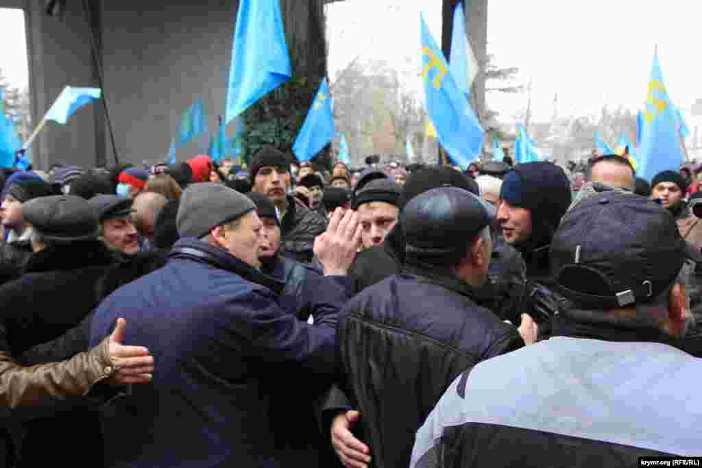 В центре Ахтем Чийгоз, замглавы Меджлиса крымскотатарского народа, сдерживает натиск людей на митинге 26 февраля 2014 года