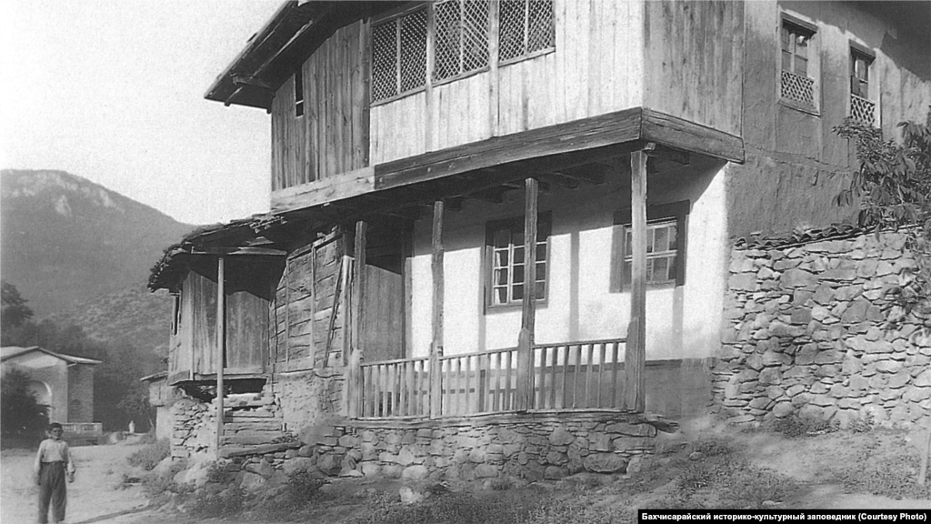 Сільський будинок. Південно-Західний Крим, 1920-ті. &nbsp; Стандартний інтер&#39;єр головної кімнати включав відкритий камін з димарем і підвішений до нього на ланцюгу казан. Уздовж стін стояли низькі диванчики з матрацами і подушками, поруч &ndash; столики. Для прикраси стін використовувалися численні рушники, а для підлоги &ndash; килими