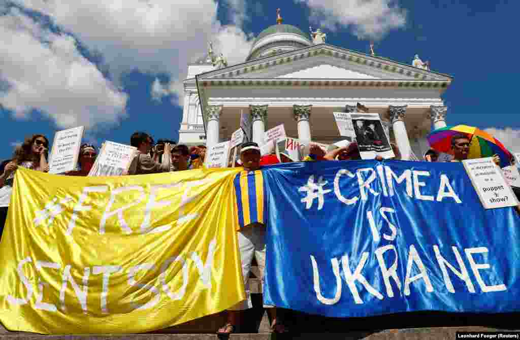 63-й день голодовки. Более двух тысяч людей митинговали в центре Хельсинки накануне встречи президентов США и России. Они развернули плакаты в поддержку режиссера