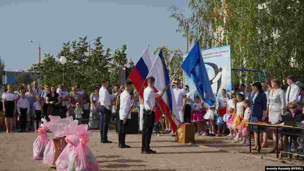 Старшокласники з прапорами гімназії, Криму та Росії